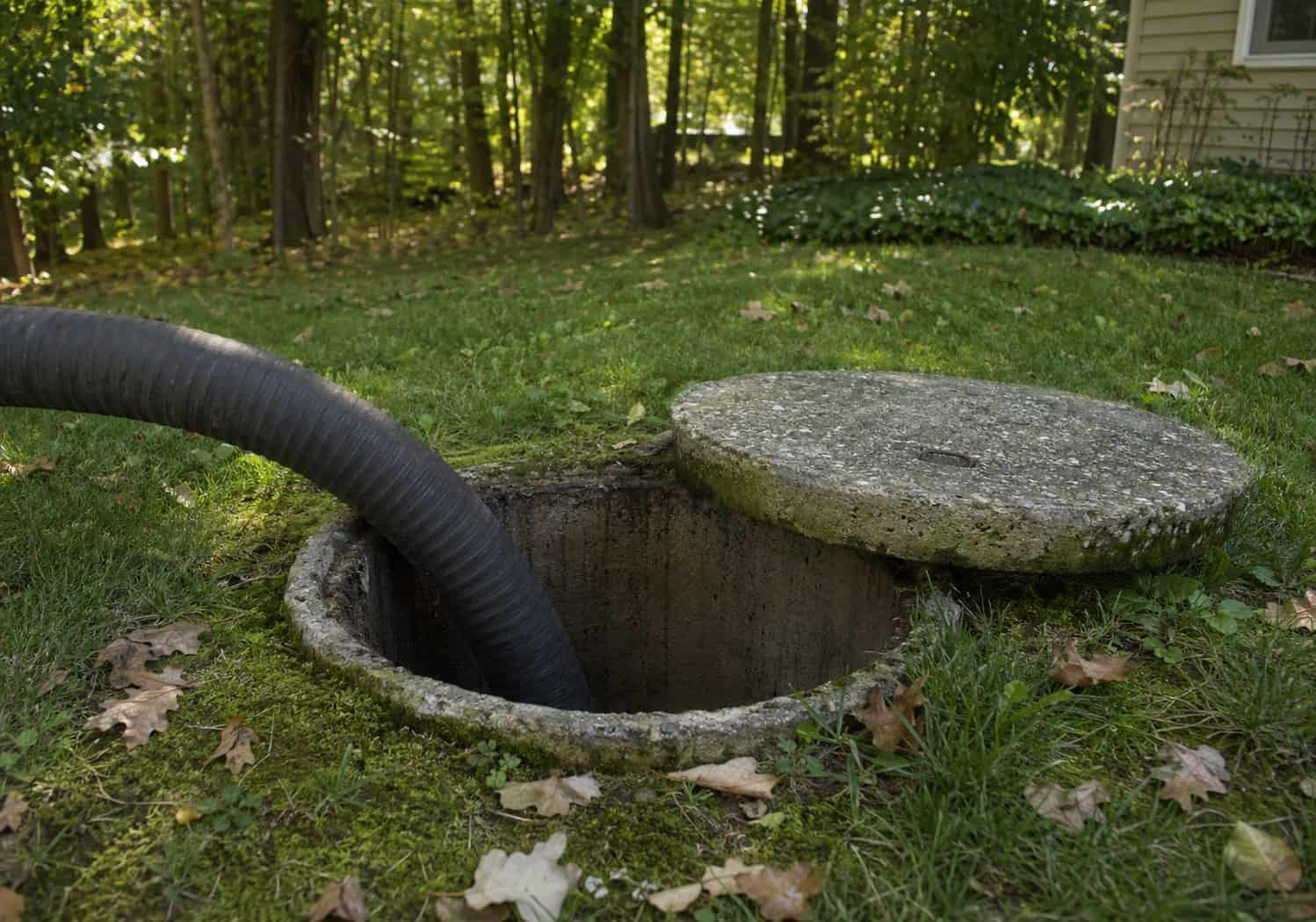 Vacuum hose feeding into an open septic tank during septic pumping in Cuyahoga Falls, OH