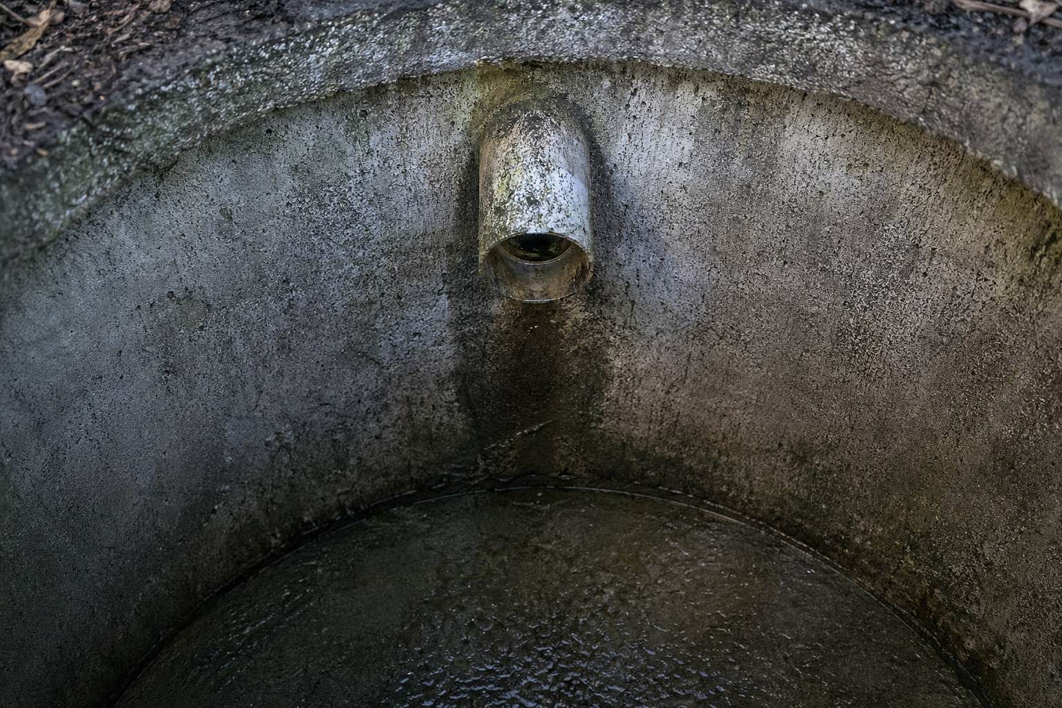 Macro view of the inlet baffle inside an open concrete septic tank during a Peninsula, OH service call